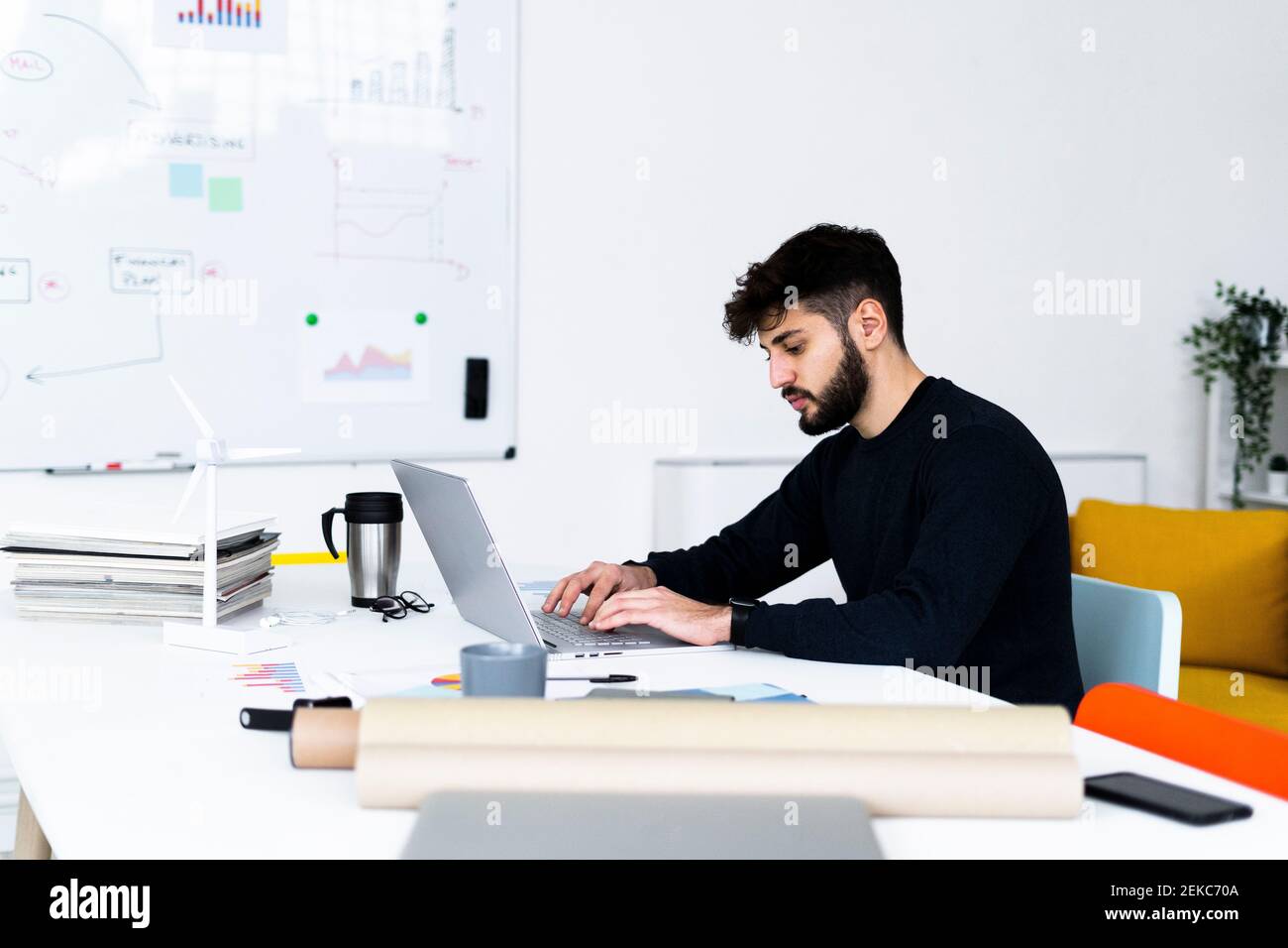 Young businessman using laptop in creative office Stock Photo