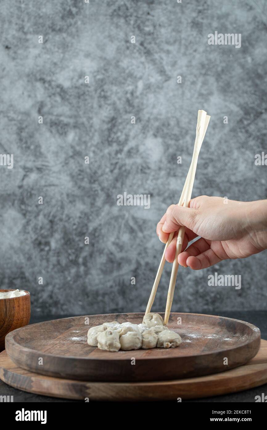 Hand holding a chopstick with a dumpling Stock Photo