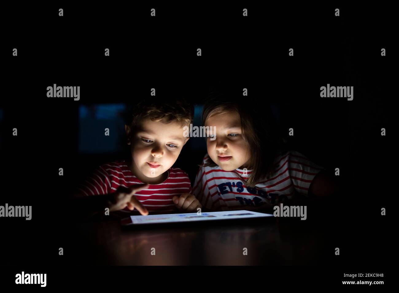 Brother using digital tablet by sister at home Stock Photo
