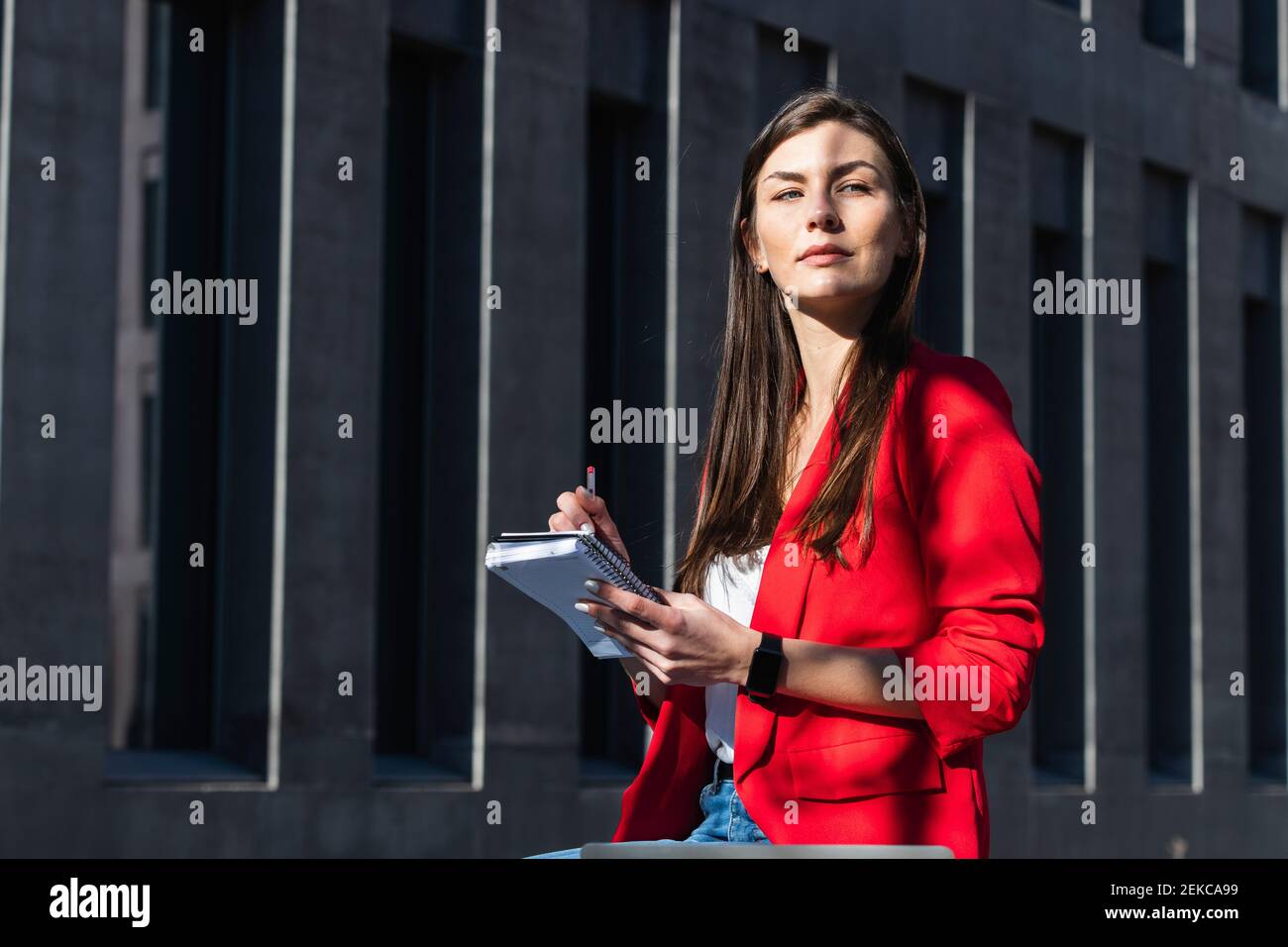 Confident female entrepreneur with diary looking away by structure Stock Photo