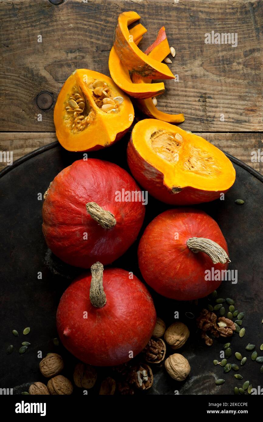 Walnuts and red kuri squashes on rustic baking sheet Stock Photo - Alamy