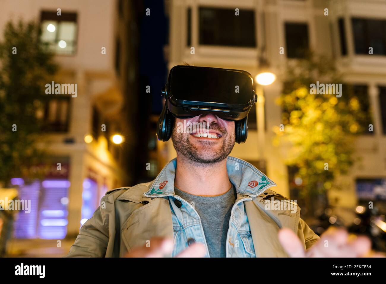 Happy man using virtual reality headset while sitting outdoors Stock ...