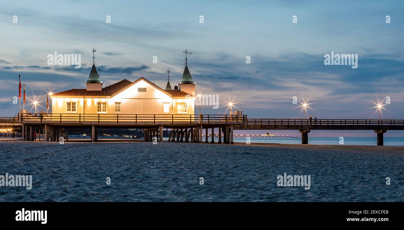 Germany, Mecklenburg-Western Pomerania, Heringsdorf, Illuminated Ahlbeck Pier at dusk Stock Photo