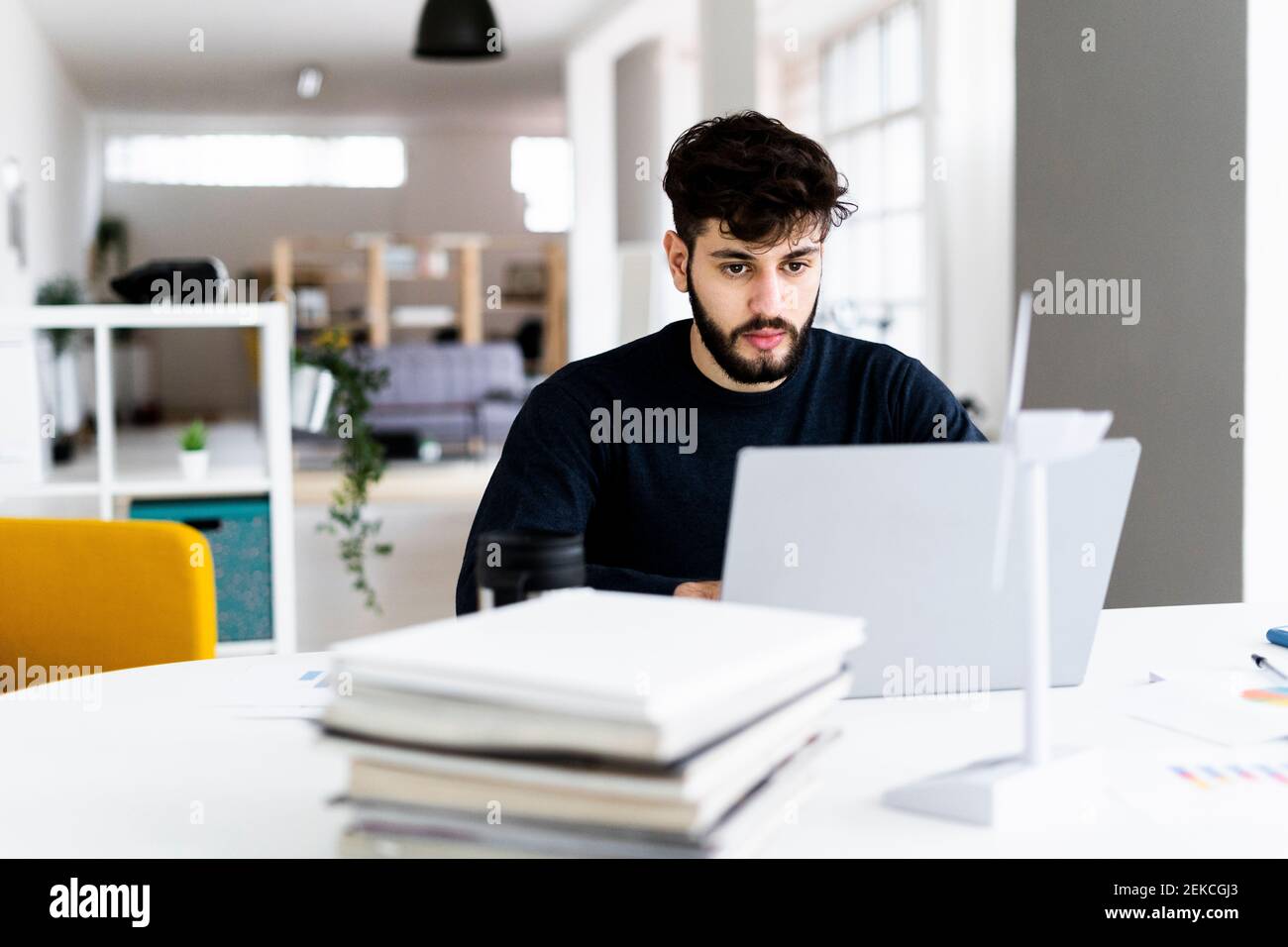 Young businessman using laptop in creative office Stock Photo