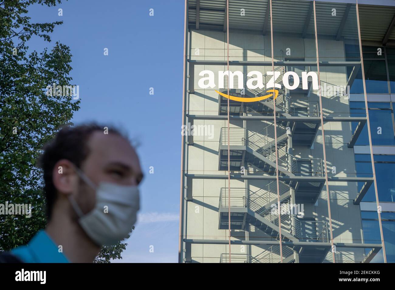 Ein junger Mann mit Maske vor dem Deutschlandsitz von Amazon in München.  Die Aktie von Amazon hat seit dem Ausbruch des Corona Virus einen Höhenflug  hingelegt. -- A young man is wearing