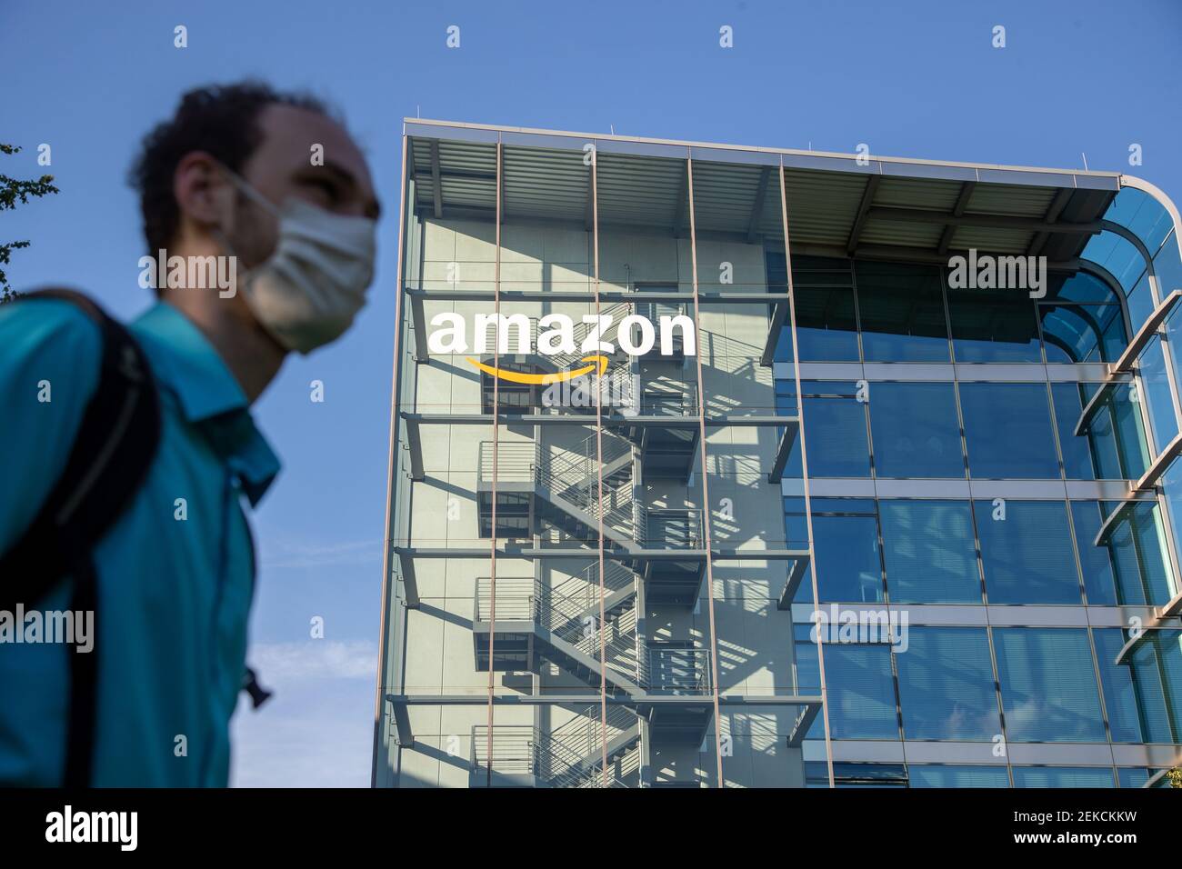 Ein junger Mann mit Maske vor dem Deutschlandsitz von Amazon in München.  Die Aktie von Amazon hat seit dem Ausbruch des Corona Virus einen Höhenflug  hingelegt. -- A young man is wearing