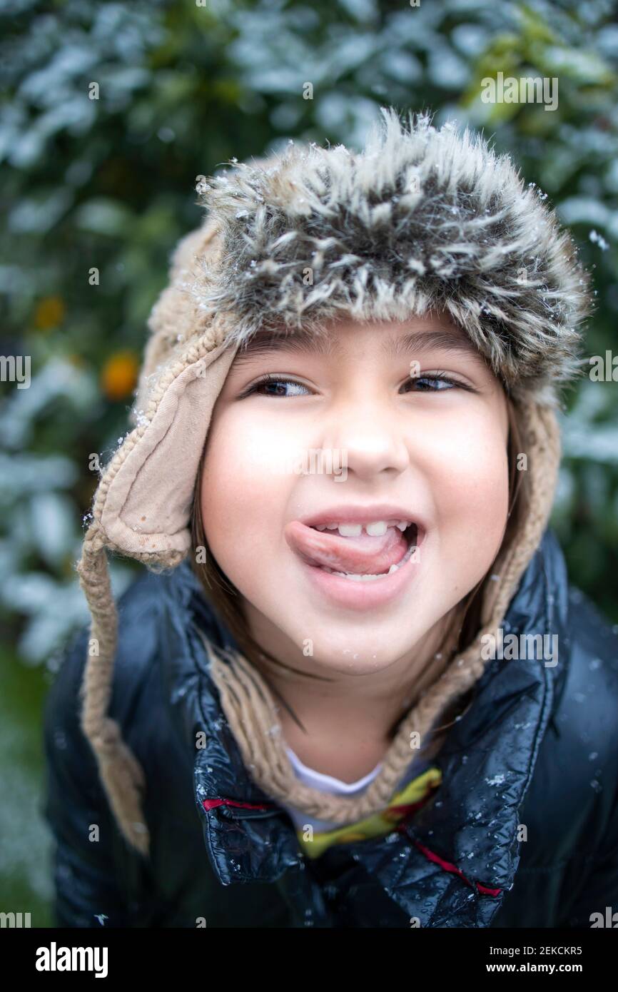 Cute smiling girl holding flower during snowfall Stock Photo - Alamy