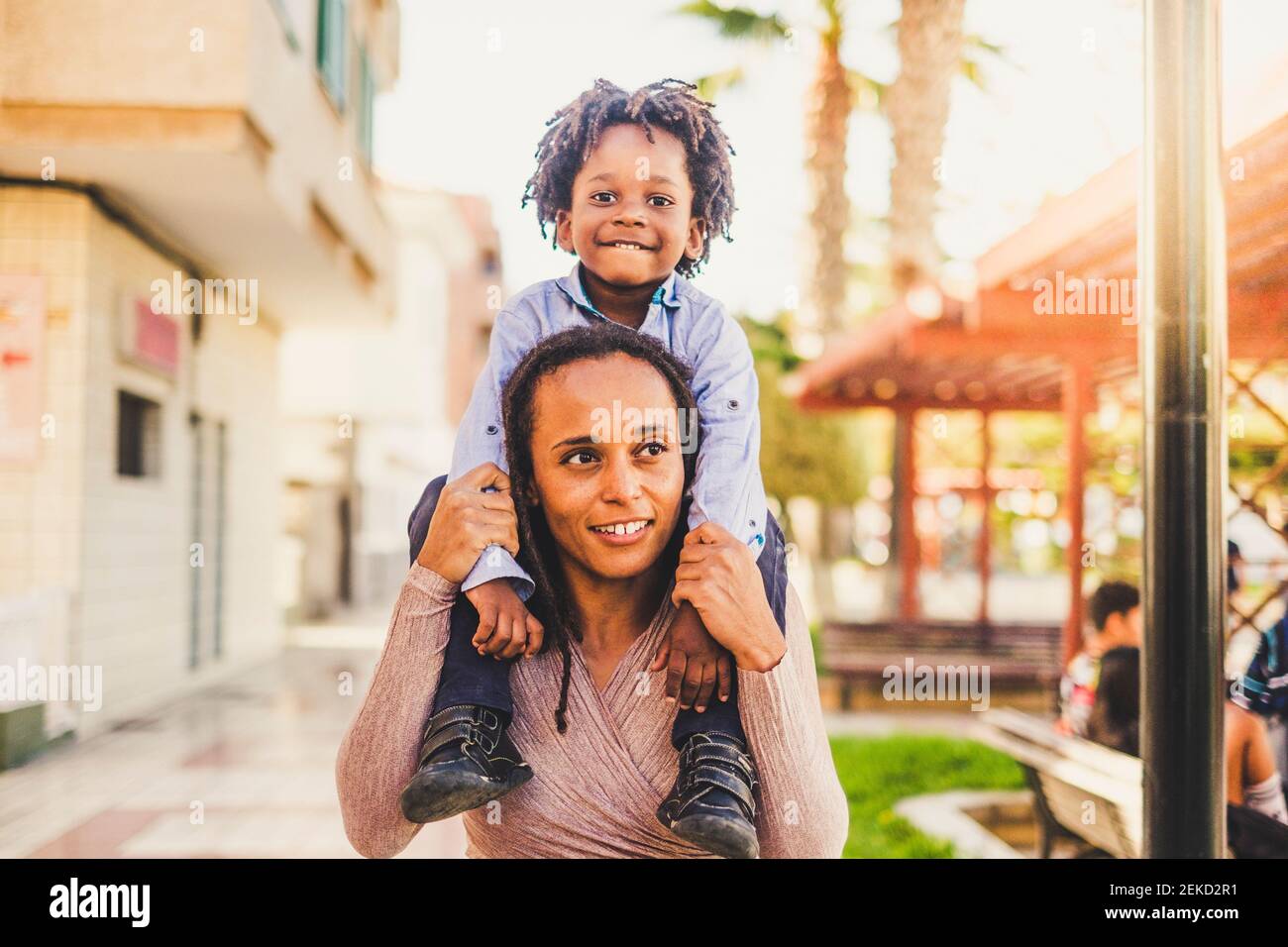 Young black mother and son together have fun and enjoy the playhood at the park  mommy take litthe boy on her shoulder - happiness and love family con Stock Photo