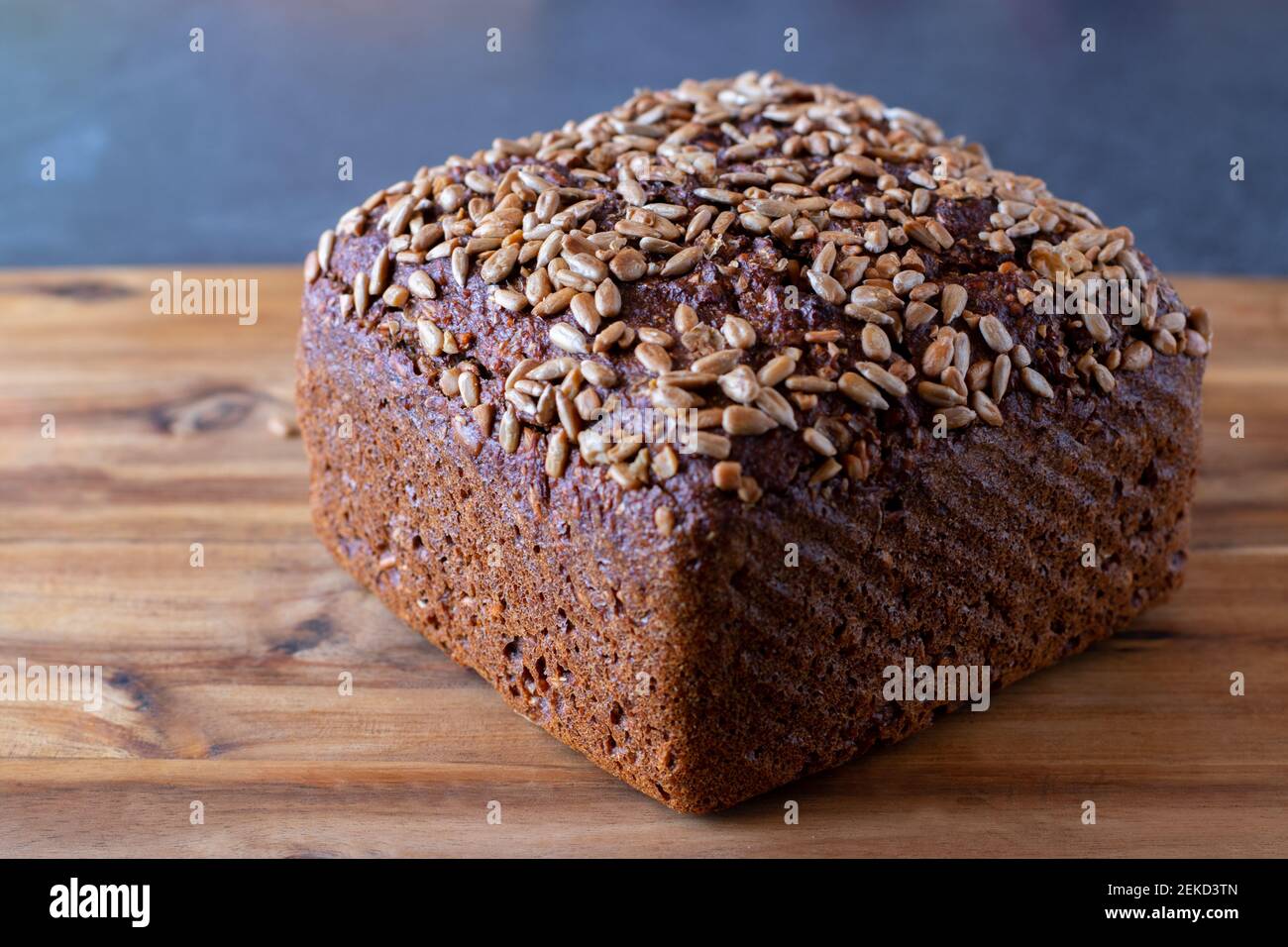A loaf of sunflower seed bread on a wooden board Stock Photo