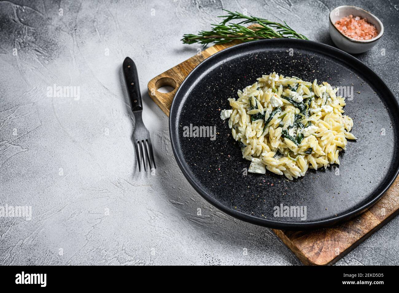 Spinach and Feta orzo pasta on a plate. White background. Top view