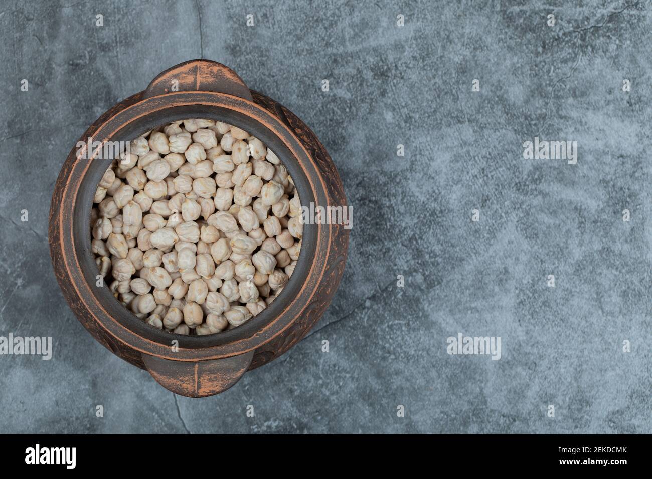 An ancient pot full of dried raw white kidney beans Stock Photo