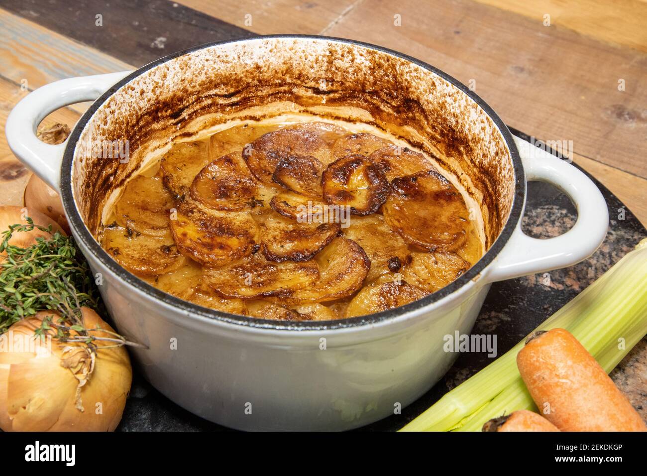 A classic British hot pot stew with slices of potatoes on top, surrounded by the ingredients