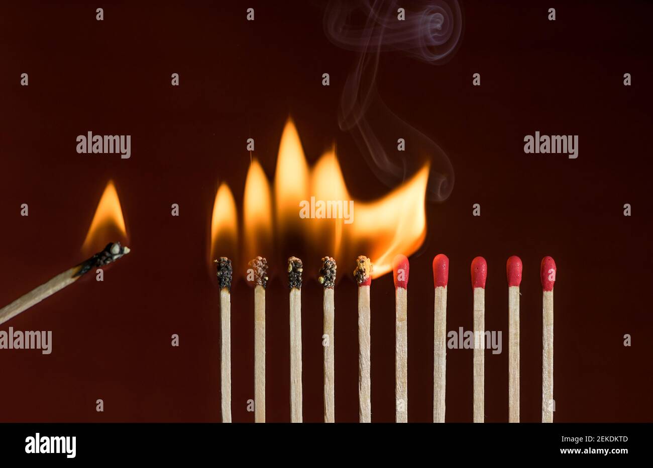 Lit match next to a row of lighting matches. Red phosphorus matches on