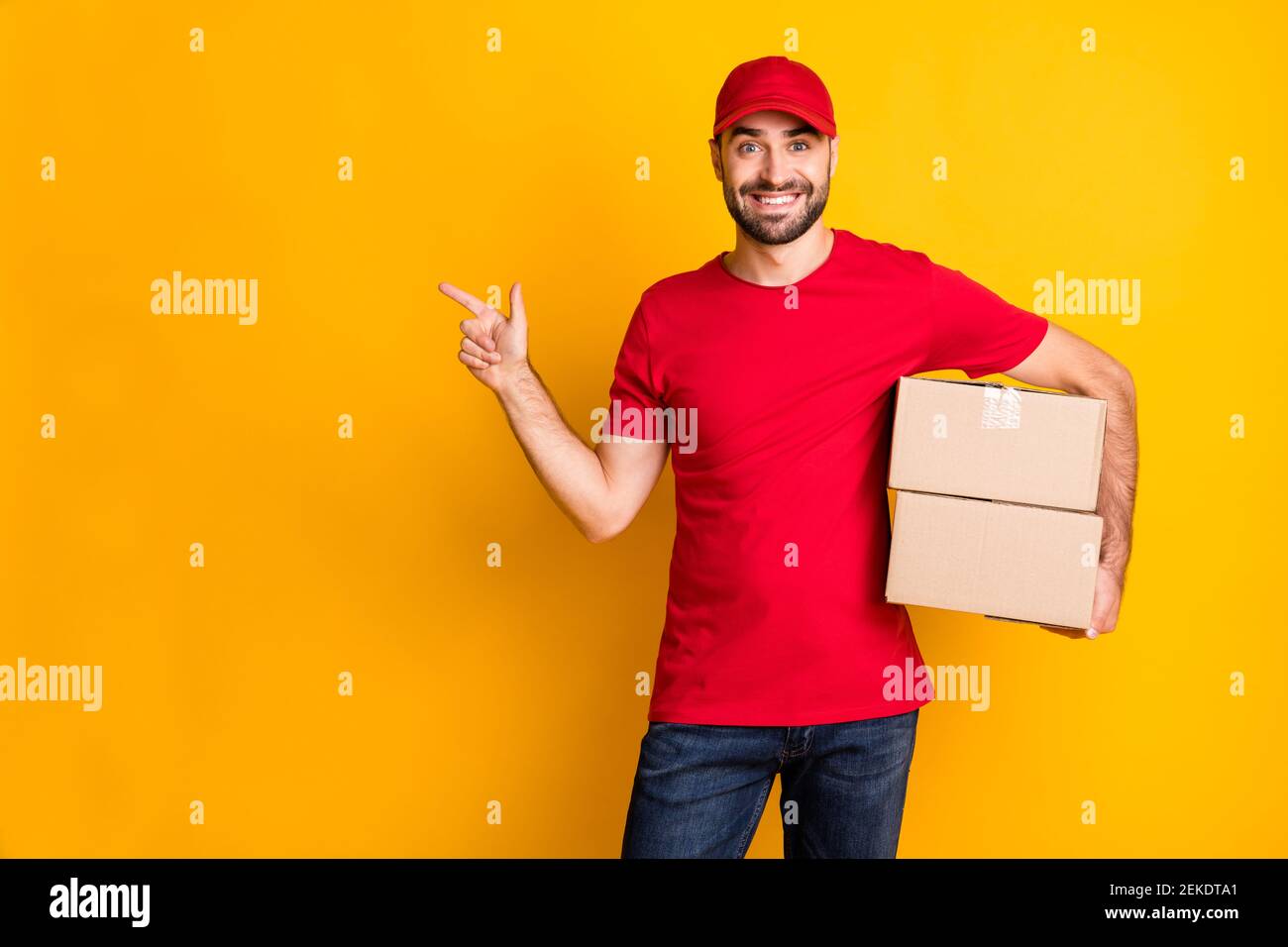 Photo of cute guy courier dressed red clothes delivering brown box ...
