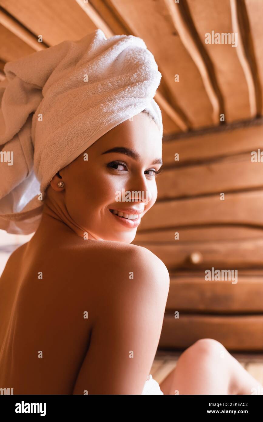 https://c8.alamy.com/comp/2EKEAC2/woman-with-towel-on-head-smiling-at-camera-in-sauna-on-blurred-background-2EKEAC2.jpg