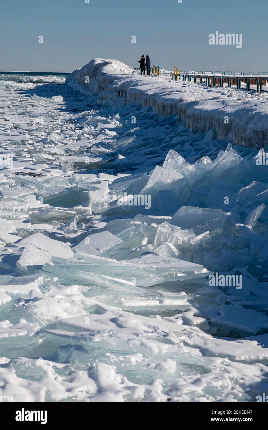 Port Sanilac, Michigan - People view ice on Lake Huron from the breakwater around the Port Sanilac Harbor. Stock Photo