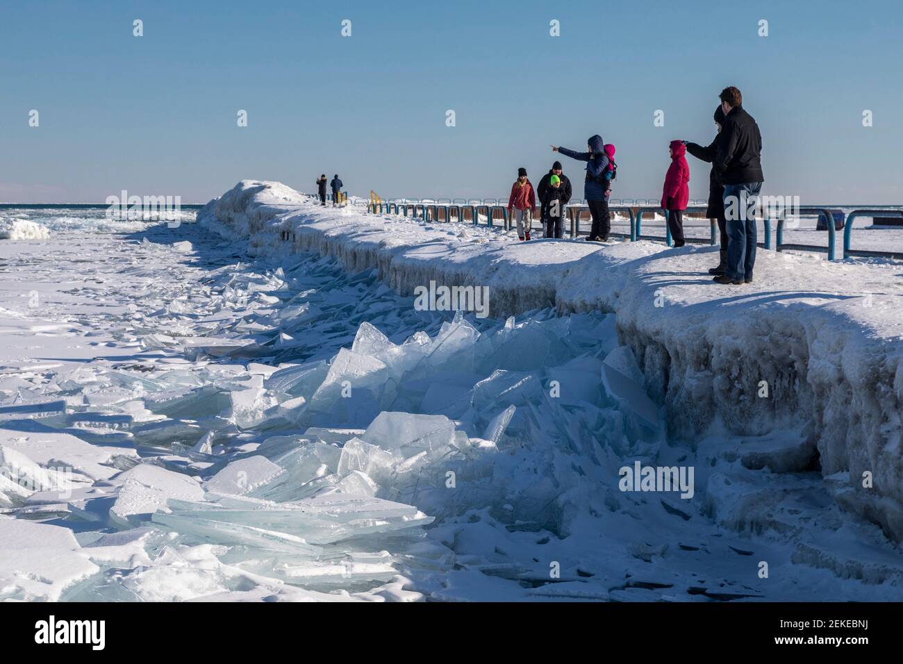 Port Sanilac, Michigan - People view ice on Lake Huron from the breakwater around the Port Sanilac Harbor. Stock Photo