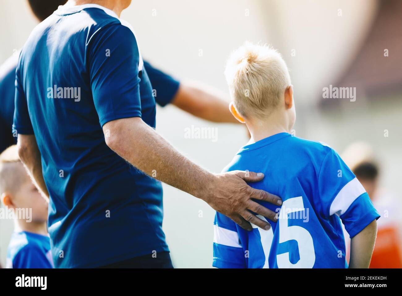 Sport Coach Supporting Young Player. Child Soccer Player Entering Game
