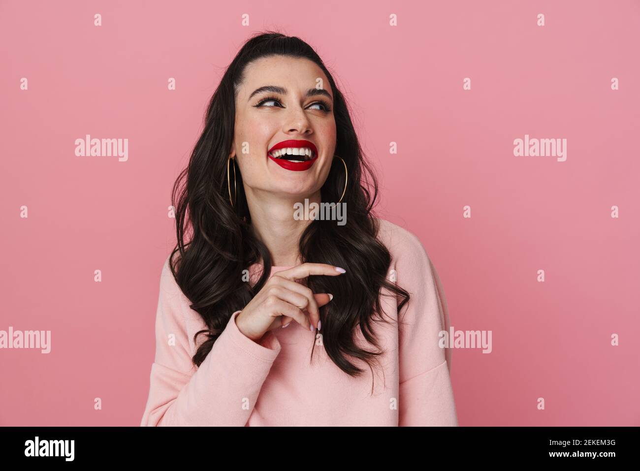 Happy beautiful girl laughing and pointing finger aside isolated over ...