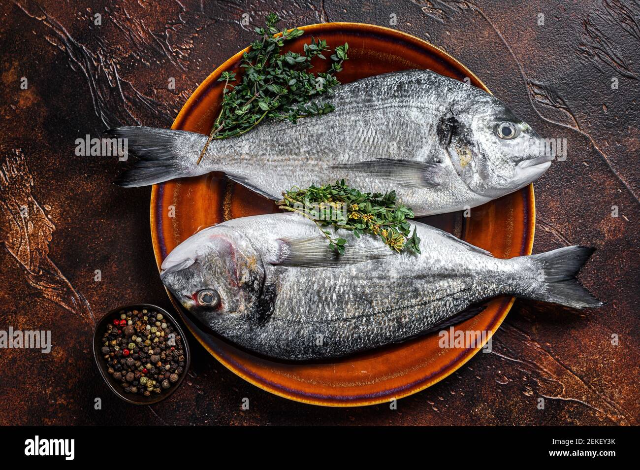 Raw Sea bream fish and ingredients for cooking. Dark background. Top ...