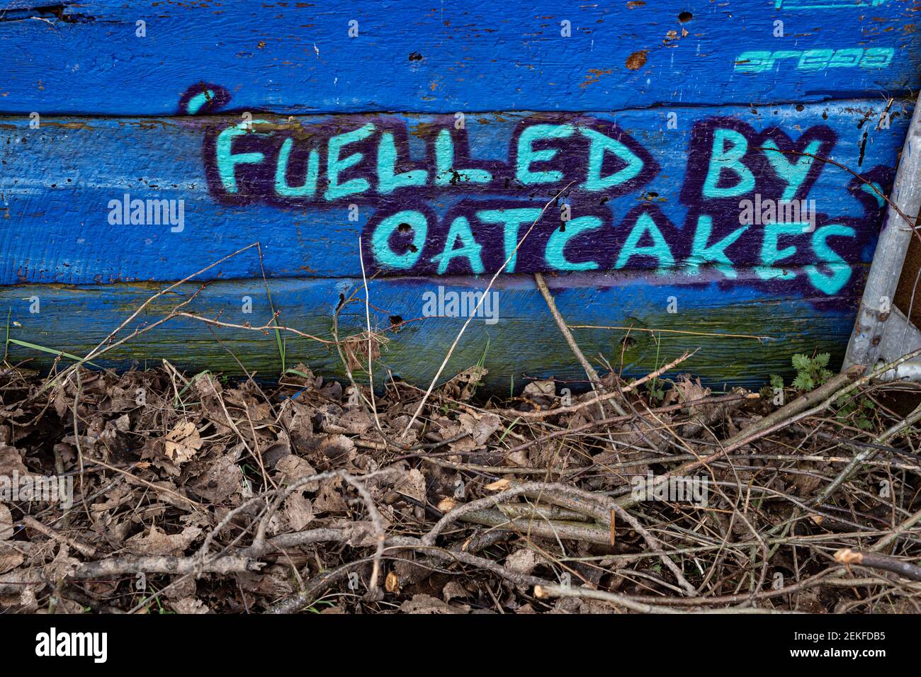 Graffiti on a fence by the Trent and Mersey canal, Middleport, Stoke-on-Trent, UK saying 'Fuelled by oatcakes' a local food of the area. Stock Photo