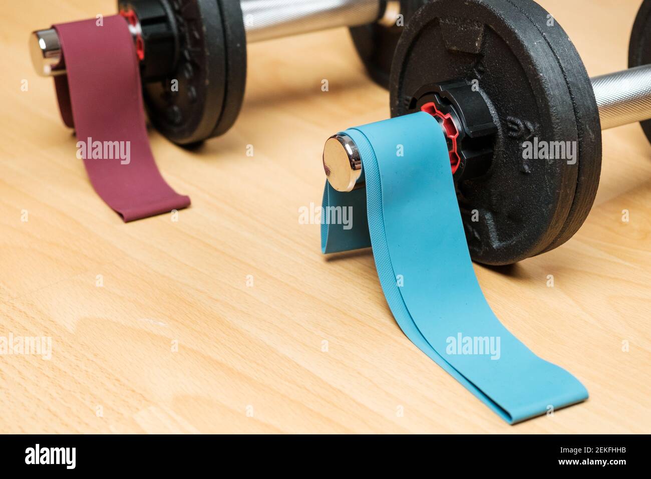 Dumbbells and elastic bands on the floor at home. Keeping fit during lockdown. Fitness equipment for strength training  Stock Photo