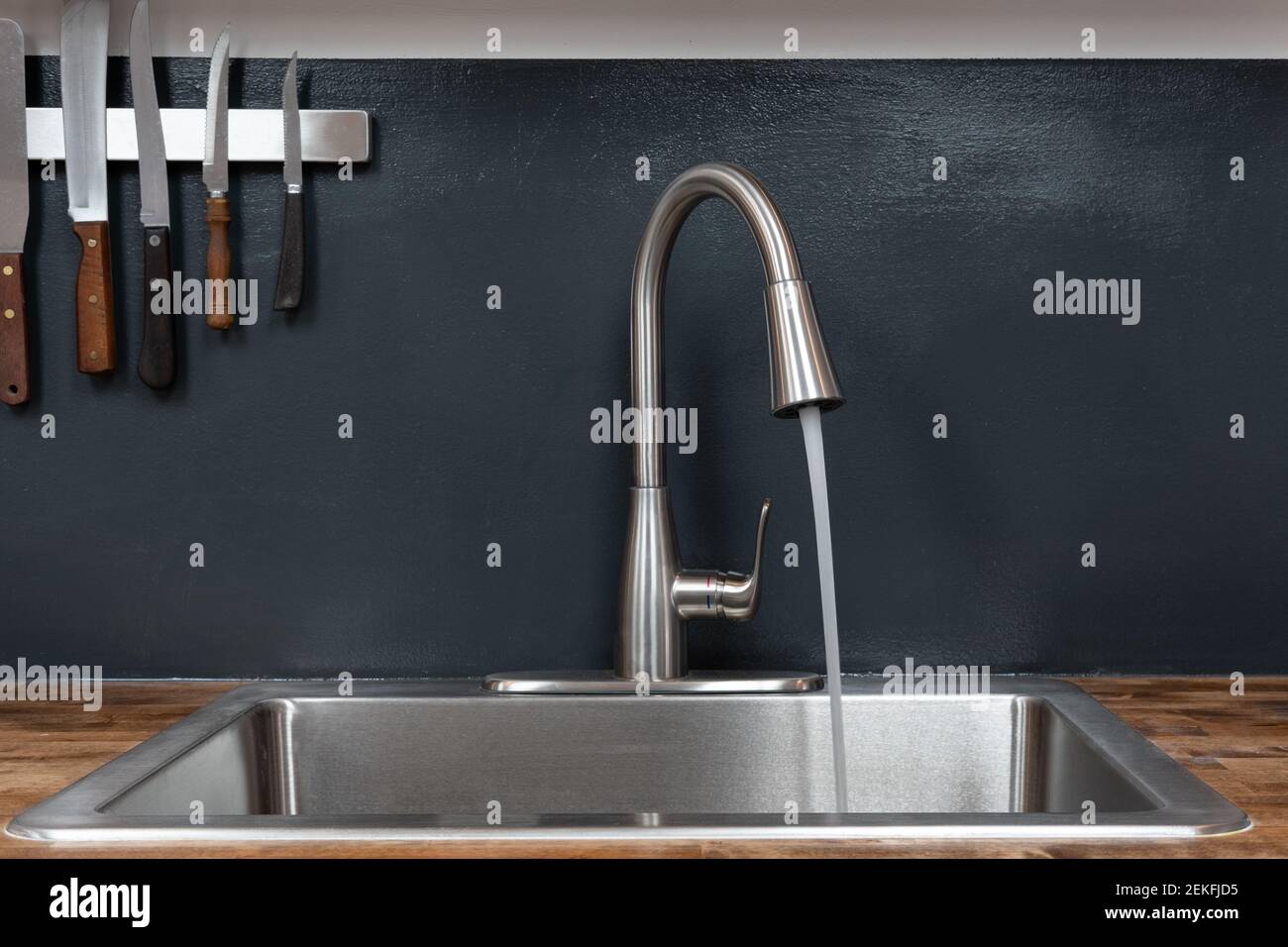 Dish sink with running water in a chef's kitchen Stock Photo