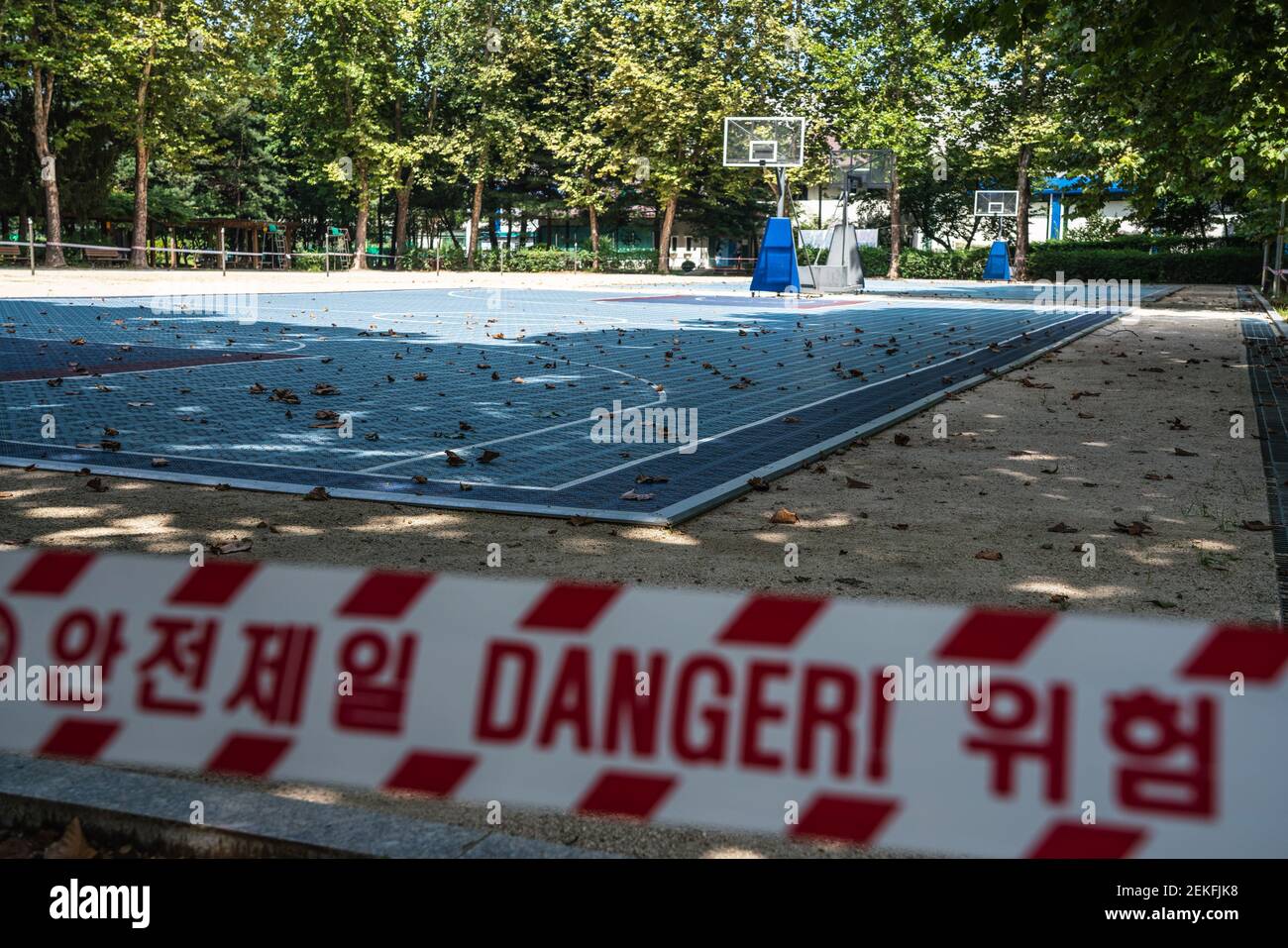 Basketball court in a park is closed off with red tape because of