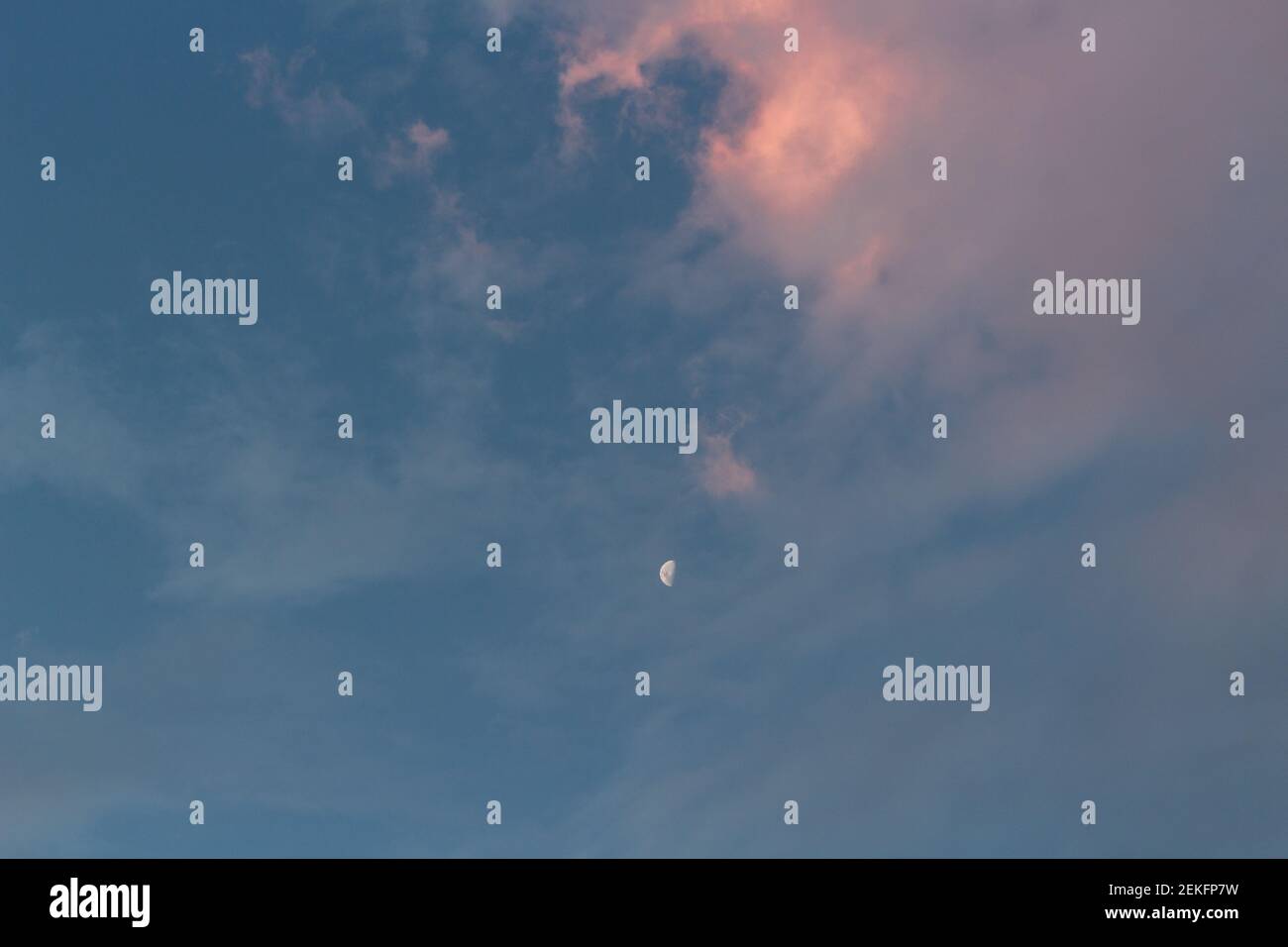 Crescent moom in a cloudy sky at sunset Stock Photo