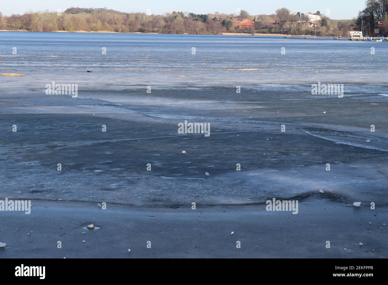 frozen lake in front of a forest Stock Photo - Alamy