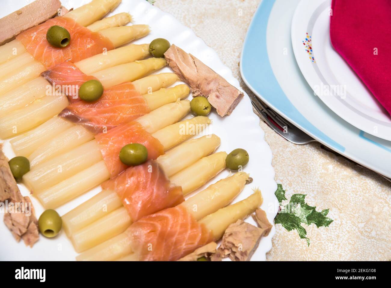 white asparagus salad with salmon, olives and tuna on white dish Stock Photo