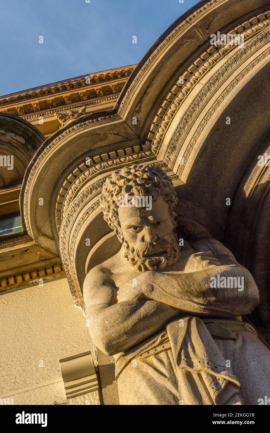 Statue of Atlas looking down from the entrance of a building on Argyle