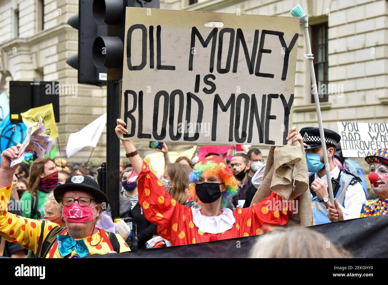 A protester holding a banner saying, oil money is blood money, during the  demonstration. Outside the HM Treasury buildings Protesters at the  Extinction Rebellion Carnival of Corruption marched towards Buckingham  Palace but