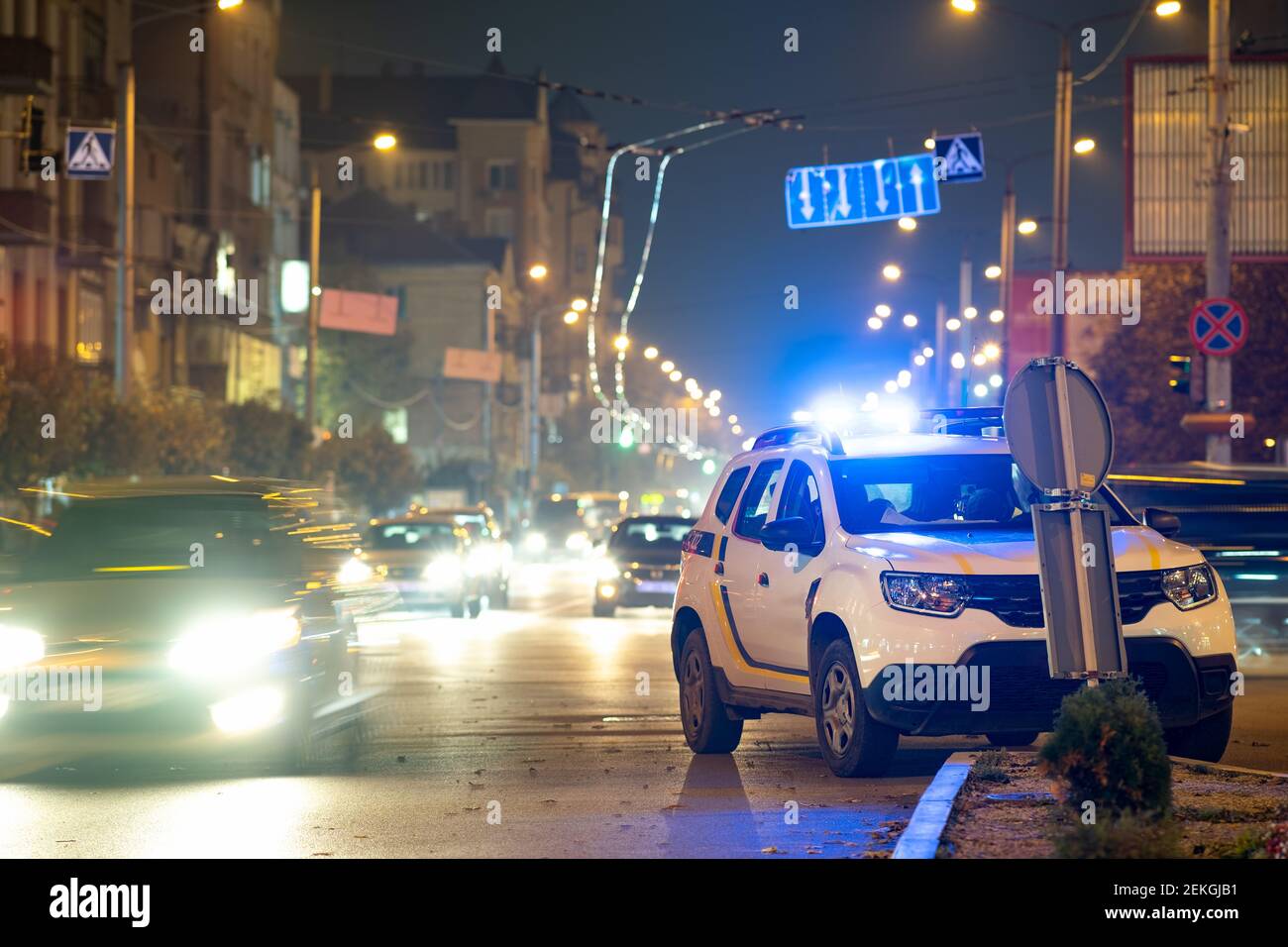 Bright flashing blue lights of police patrol car parked on city street
