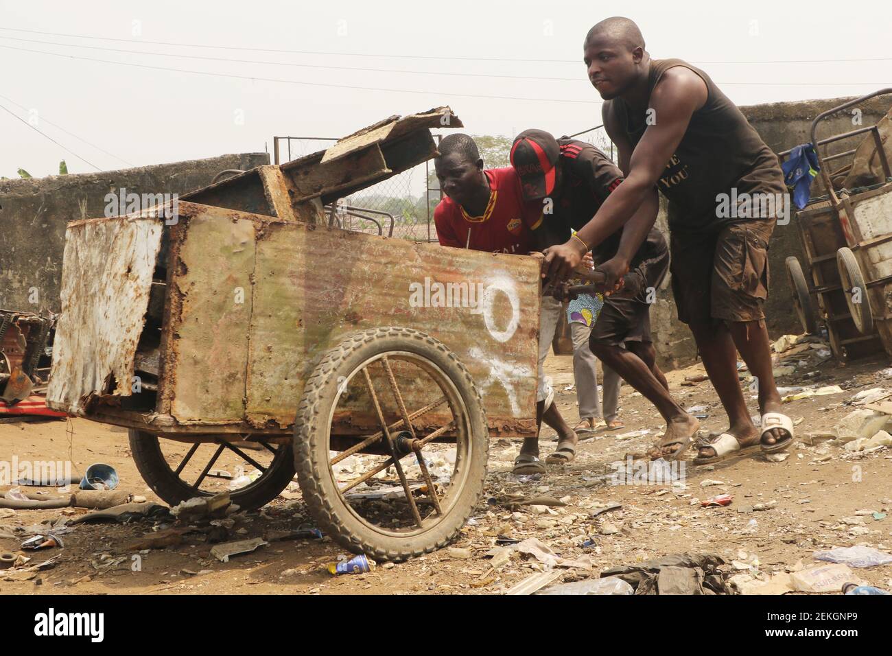 Calabar, capital of Cross River state, Nigeria. 23rd February 2021. Scavengers push a cart as they load and evacuate the wreckage of a abandoned rust iron for scale at a trash dump site. A group of scavengers make their living from a trash dump, amidst wide spread of unemployment in Nigeria. Stock Photo