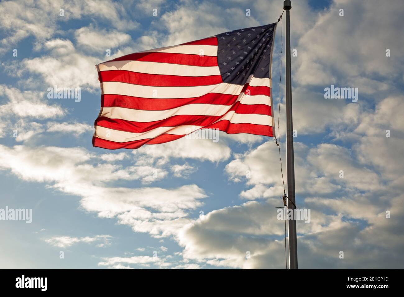 WA19317-00...WASHINGTON - American flag flying on Pier 57, Miner's Landing, overlooking Elliott Bay at sunset. Stock Photo