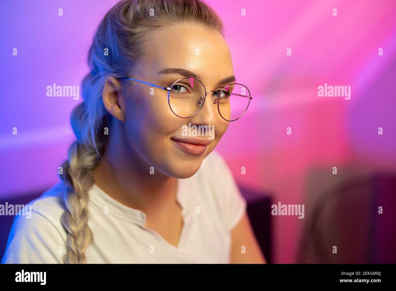 Portrait of Gamer Girl with Glasses Playing Online Video Game on Her