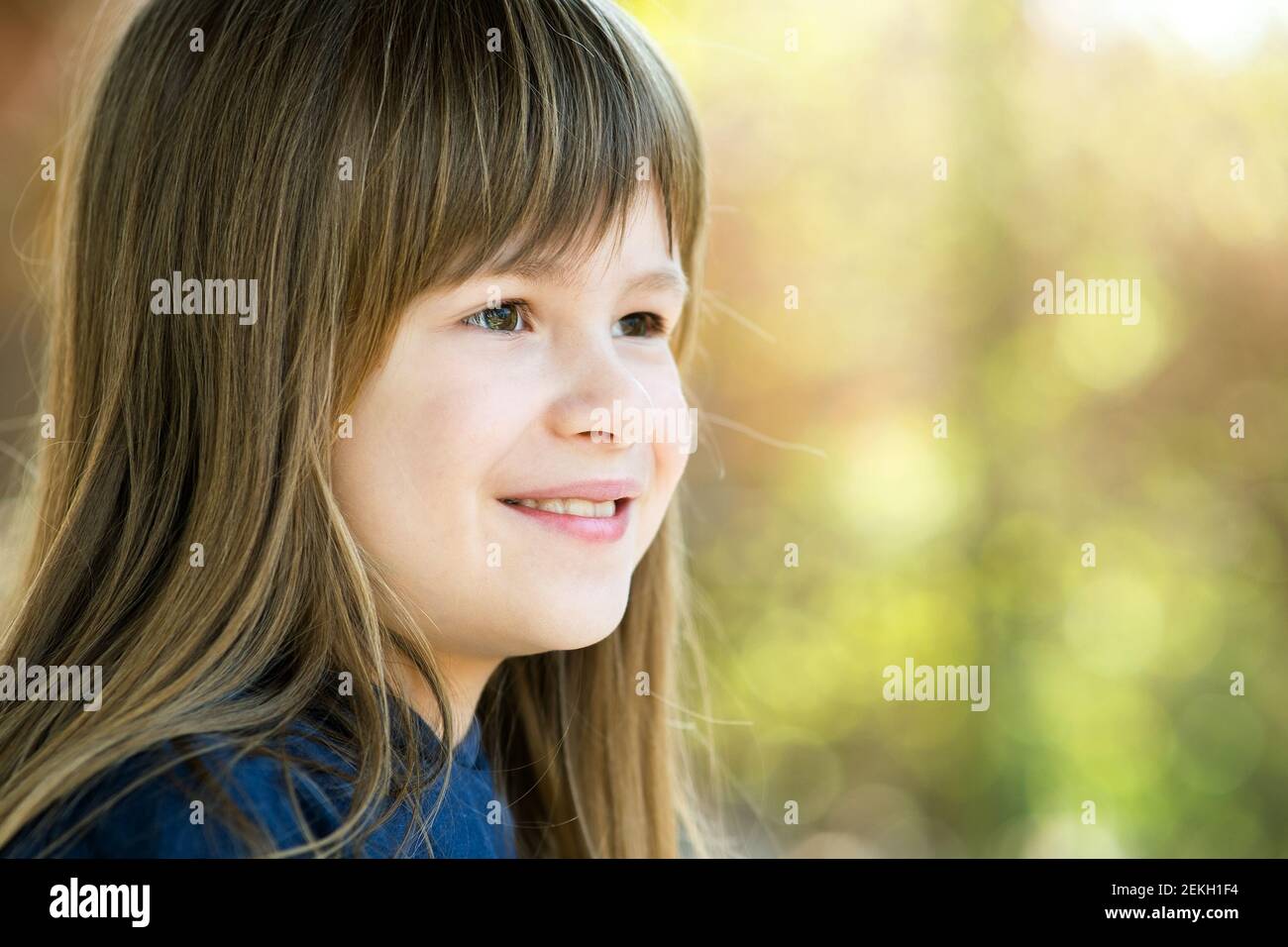 Portrait of pretty child girl with gray eyes and long fair hair smiling