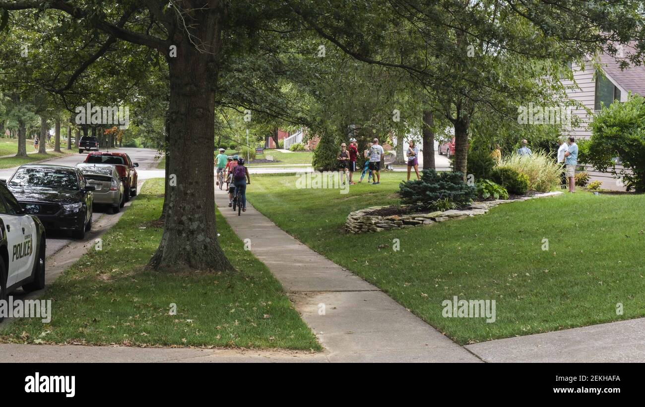 Neighbours watch as the Bloomington Police Department investigates