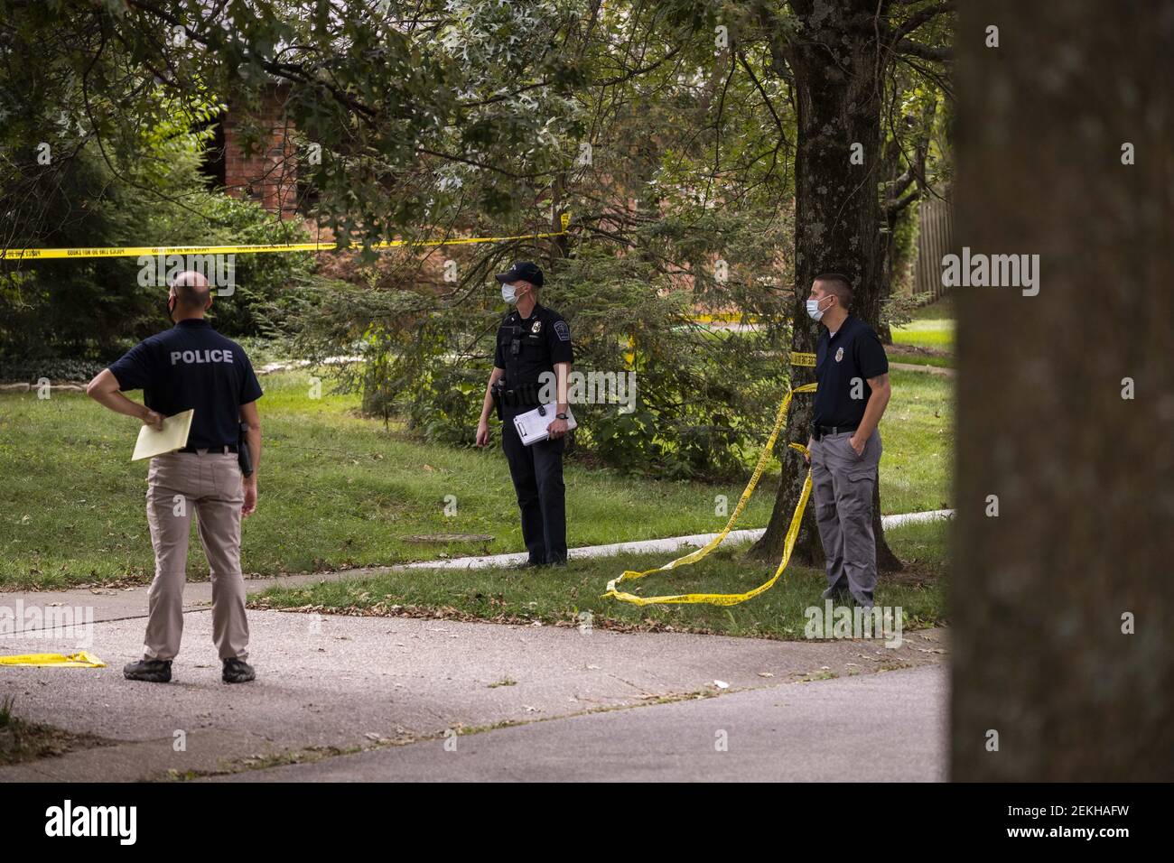 Bloomington police watch as bodies are placed in a coroner's vehicle