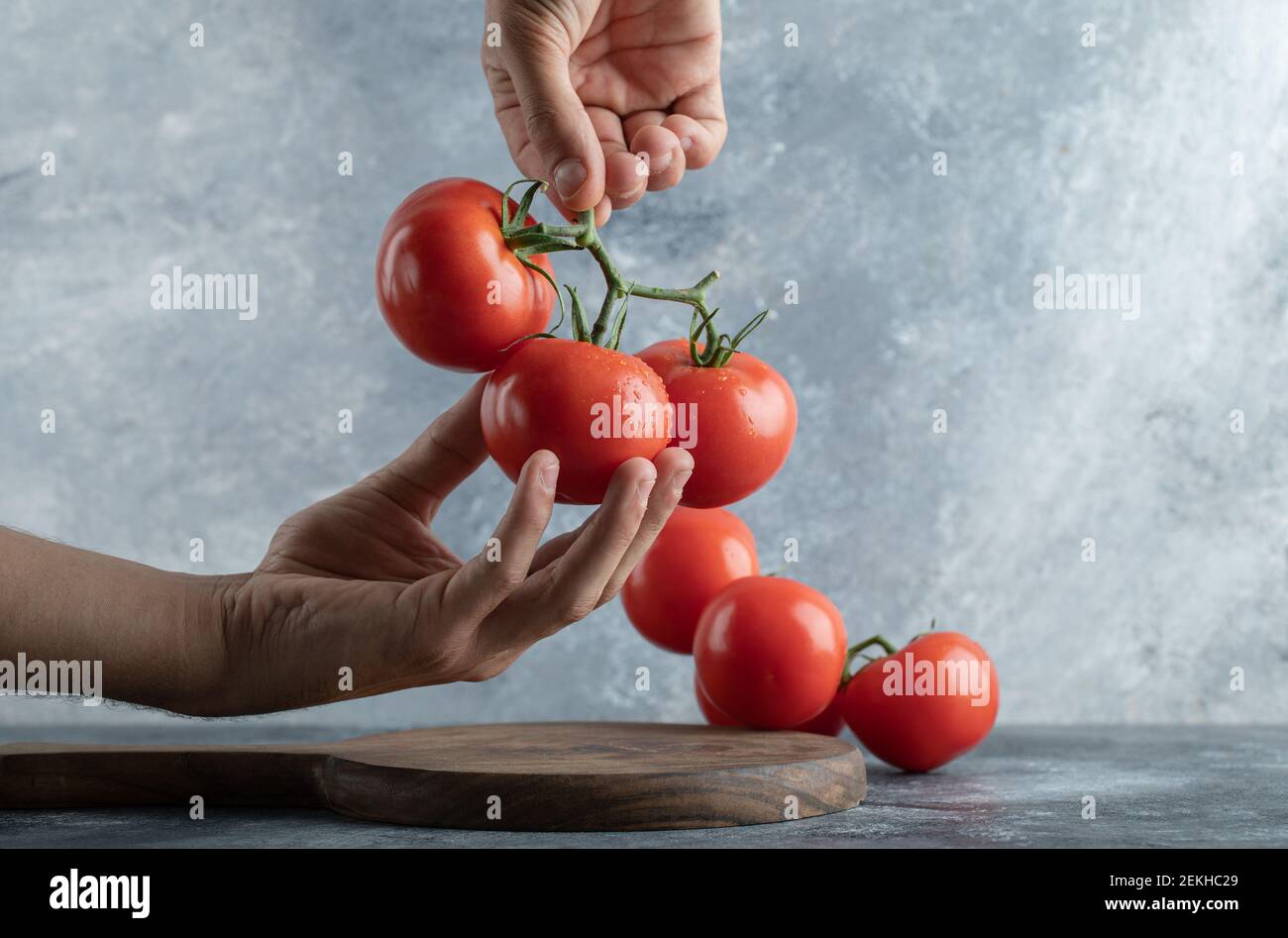 Man hands holding a bunch of juicy tomatoes Stock Photo - Alamy