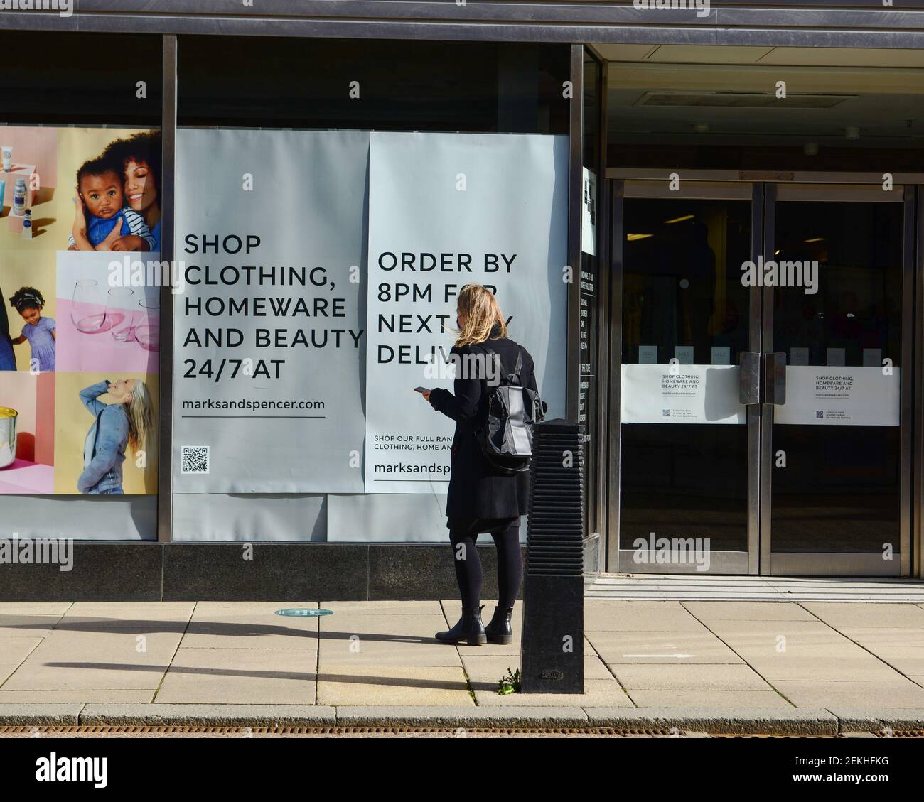Cambridge , UK, 20-02-2021., Retail outlet Marks and Spencer store closed with adult looking at window advertising during world wide pandemic Stock Photo