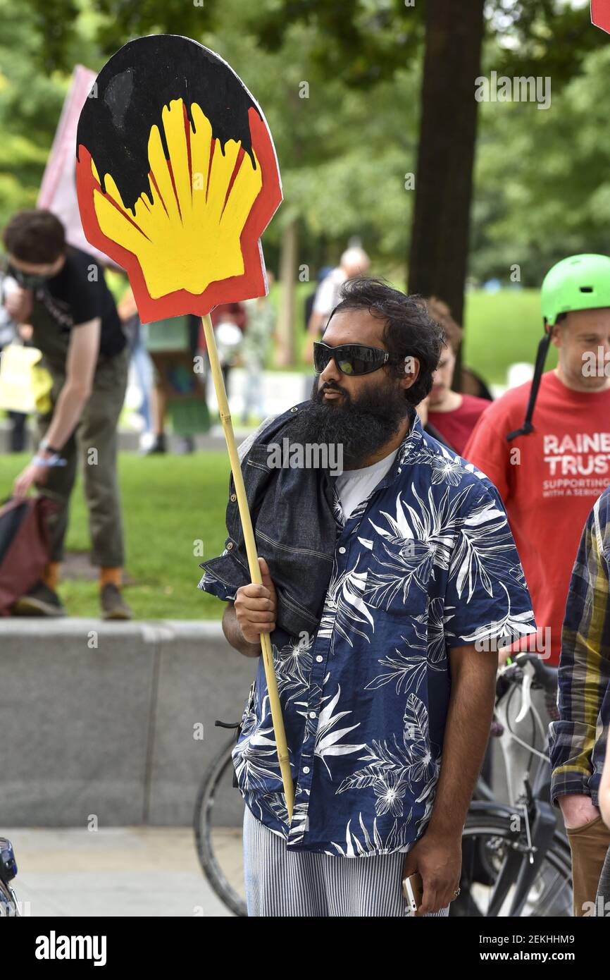 An man holds a placard with the Shell logo with oil on it outside Shell ...