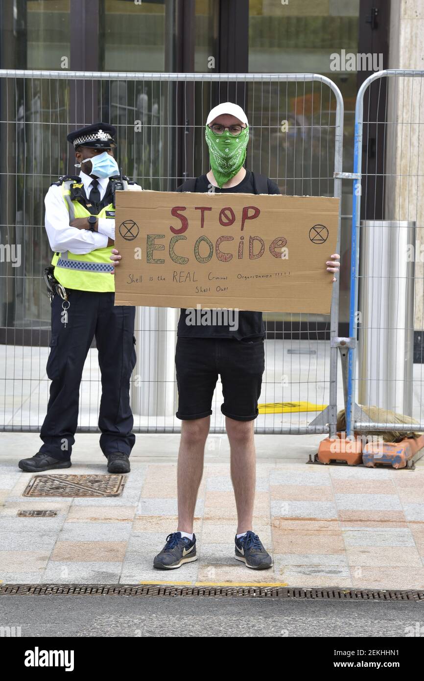 An man wearing a mask holds up a protest placard during the Extinction ...