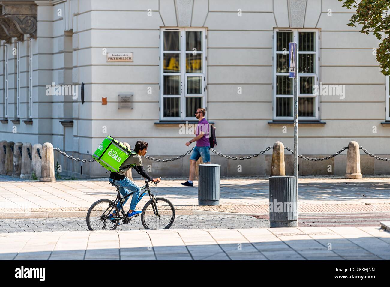 Warsaw, Poland - August 23, 2018: Uber eats bicycle man person with green sign in old town historic street in capital city during sunny summer day Stock Photo