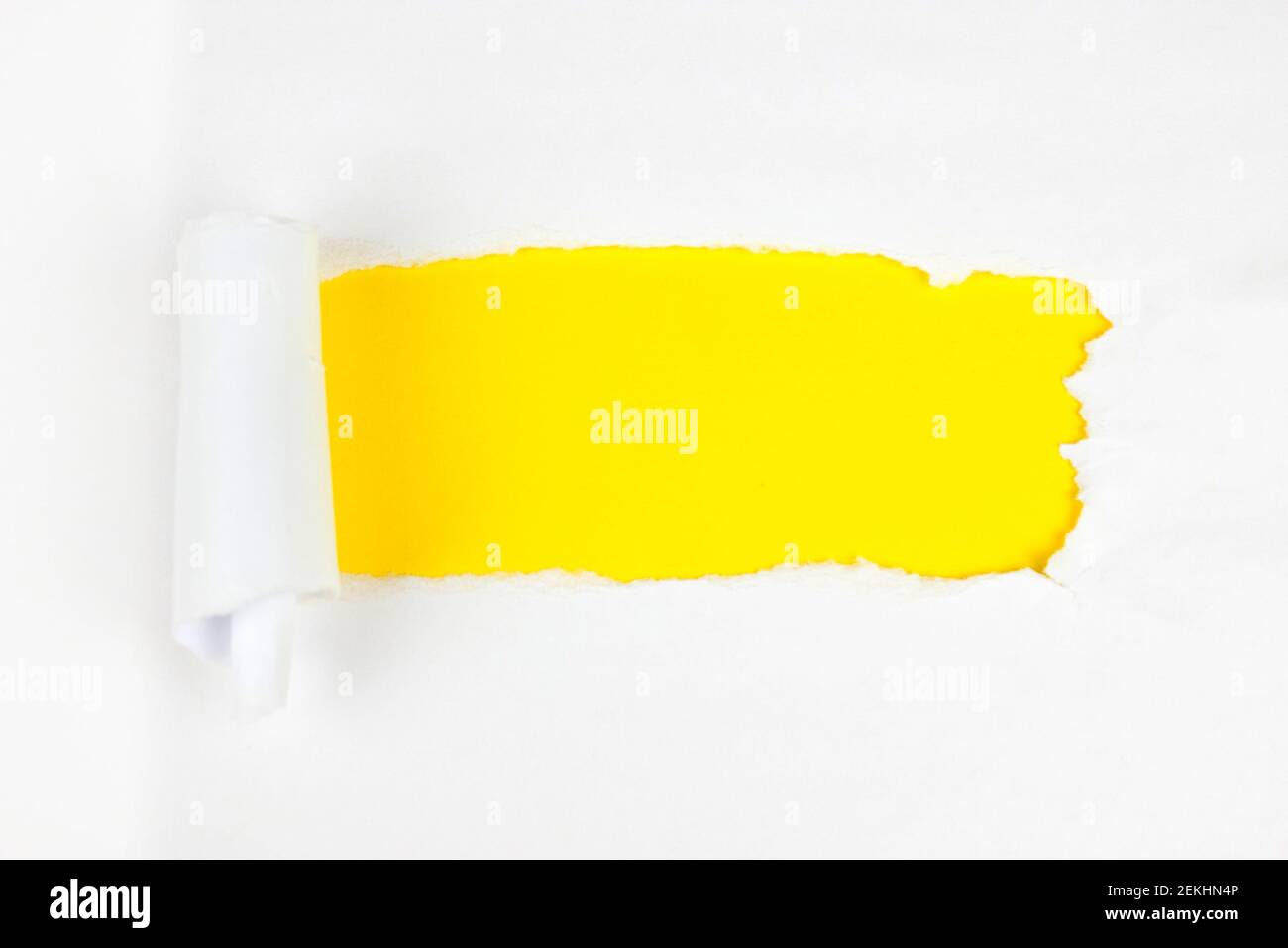 Piece of hole white paper on yellow. Copy space. Stock Photo