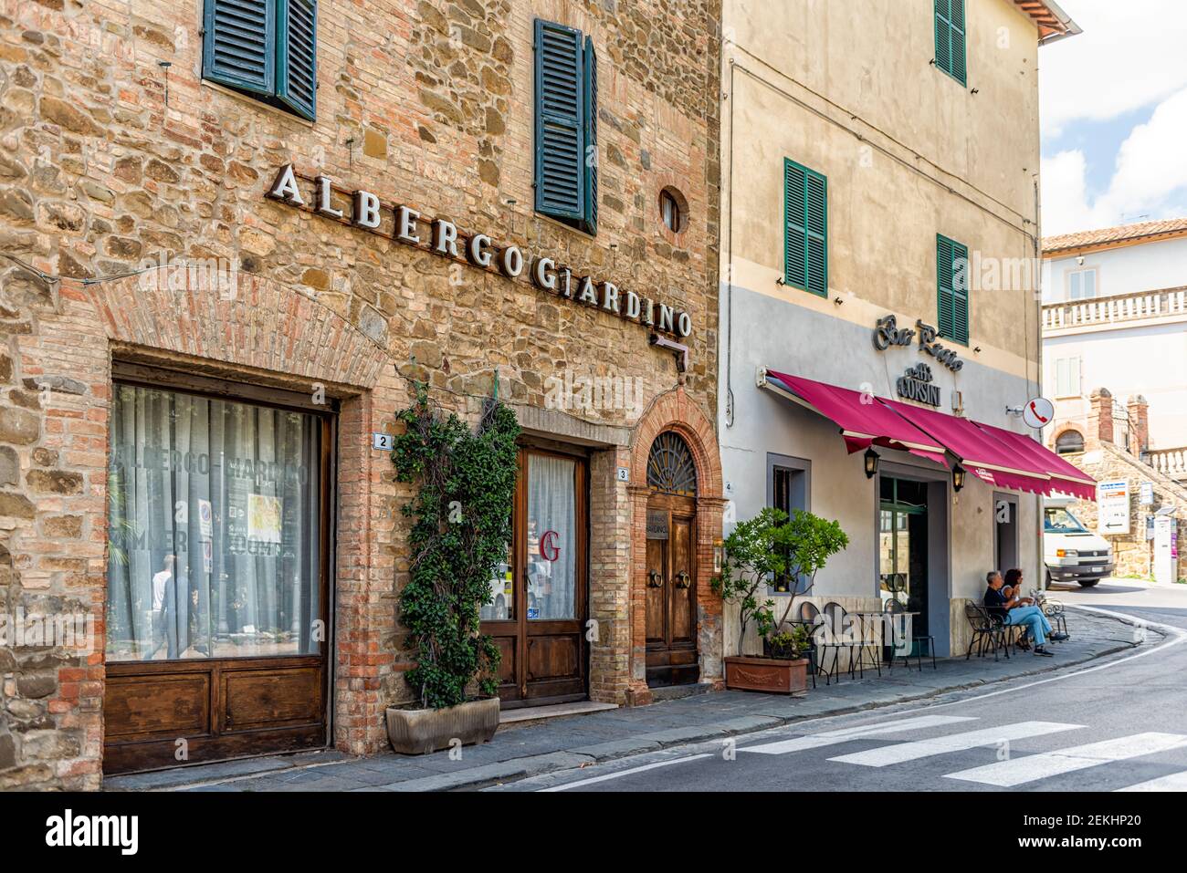 Montalcino, Italy - August 26, 2018: Street in town village in Tuscany during summer and cafe restaurant store with sign for Albergo Giardino hotel Stock Photo