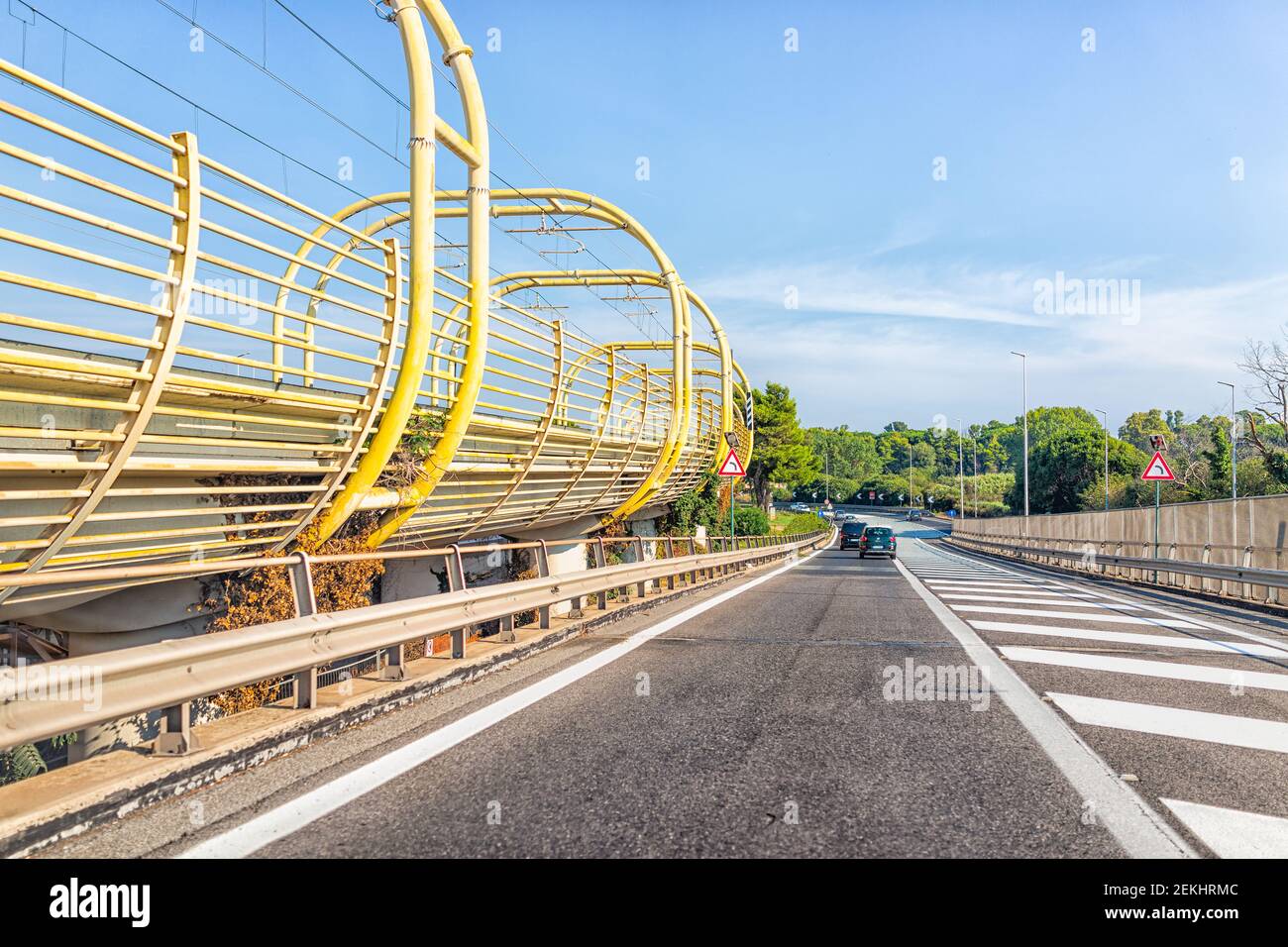 Rome, Italy - August 24, 2018: Sunny summer day and highway road street from airport with modern autostrade and yellow train rail Stock Photo