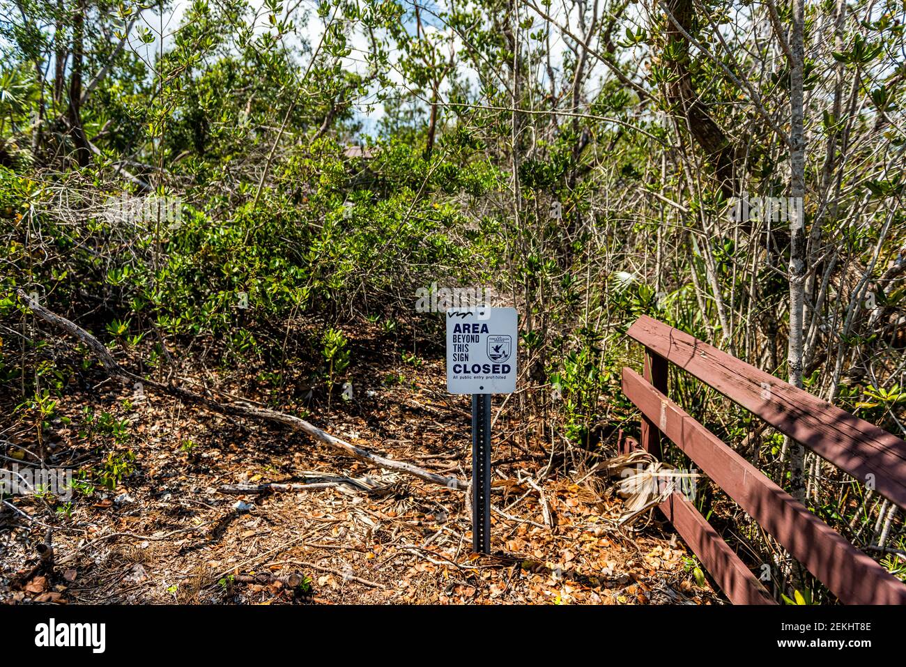 Big Pine Key, USA - May 1, 2018: Florida Keys island with trees damaged by wind after hurricane Irma with sign Area beyond is closed Stock Photo