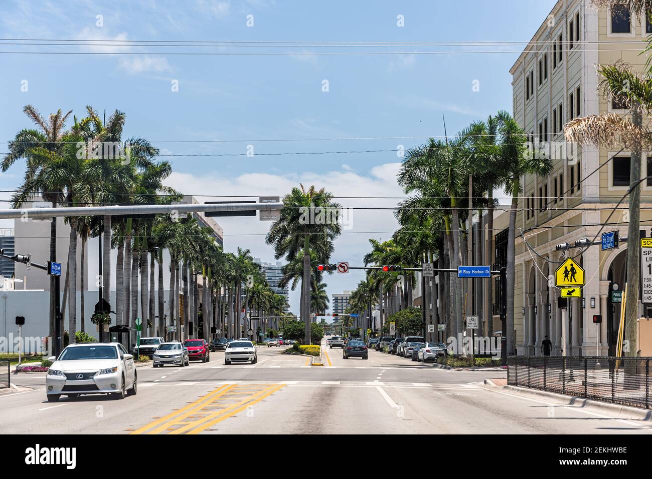 Bay Harbor Islands, USA - May 8, 2018: Intersection of 96 street and West Bay Harbor drive in Miami Dade county, Florida with people walking and cars Stock Photo